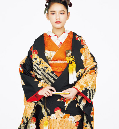 和装(本振袖)の服のコーディネート:椿/漆黒の艶めきに凛とした菊の刺繍。夕焼けのような優しい褐色の掛下が女性らしさを演出してくれます。華やかにちりばめられた赤色と目元に潜ませた蘇芳色が印象的。