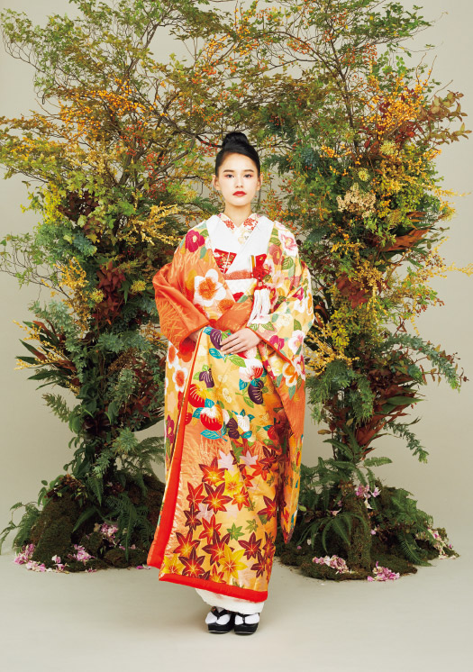和装(色打掛)の秋のコーディネート:赤朽葉/紅葉とともにあしらわれる梅・橘・椿を身に纏うその姿は、 温かく、美しい。季節を先取る粋な装いを表現した 物語のある色打掛に、同系色のお小物を合わせることで 花嫁自身の魅力を引き立たせます。