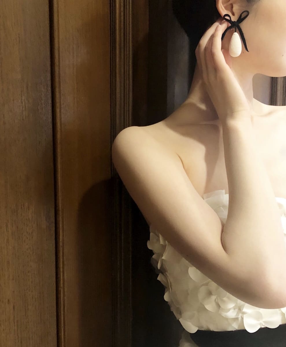 エリザベスフィルモアの3Dフラワーのウエディングドレスに丸みのおびたイヤリングを合わせたスタイル