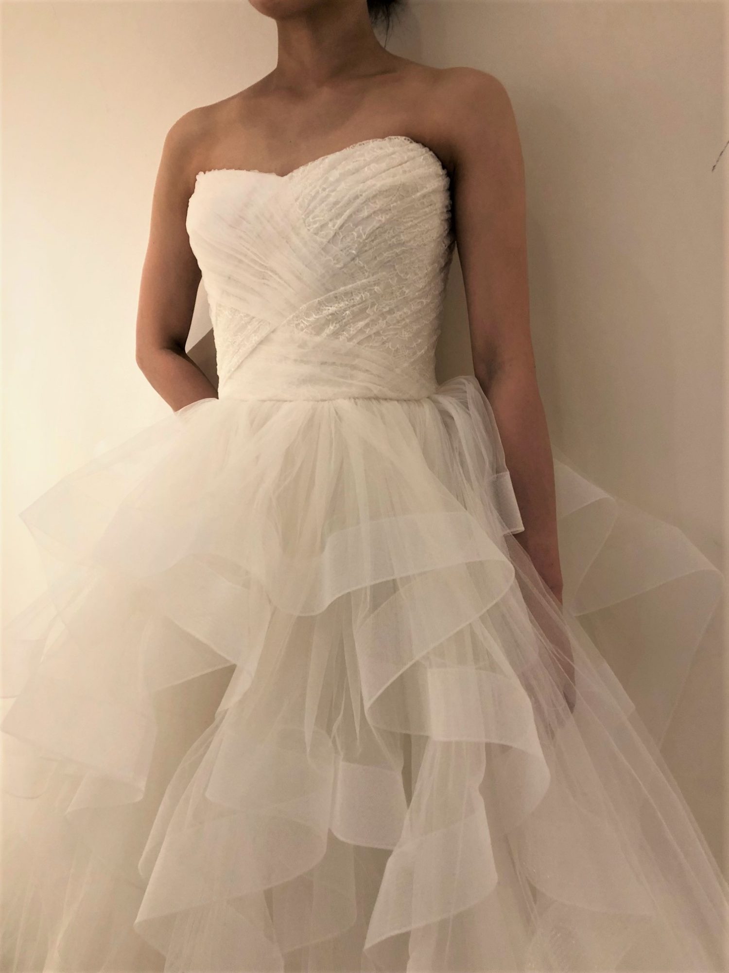柔らかく揺れ動くラッフルフリルが軽やかな印象のリーム・アクラのウェディングドレスは、バーニーズニューヨーク横浜店で海外レンタルドレスとしてご紹介しております