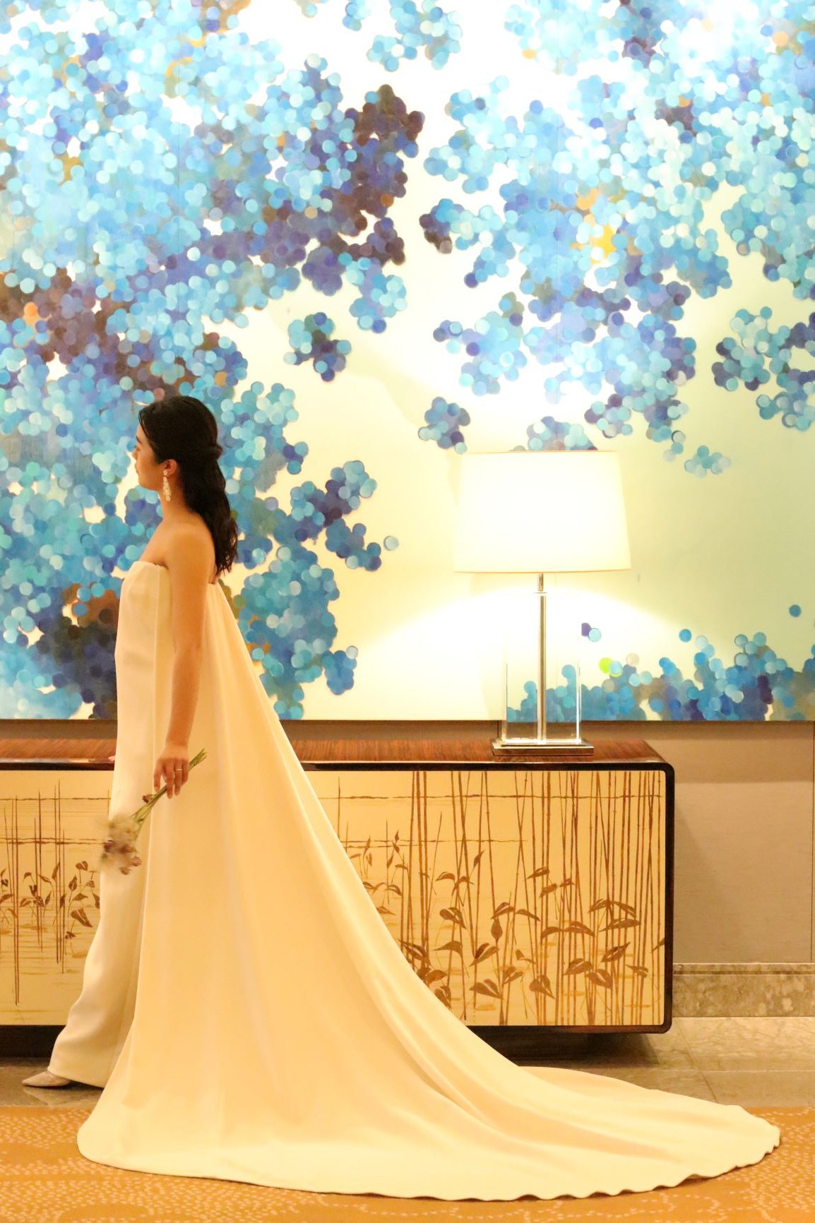 アメリカンクラシックを代表するキャロリーナ・ヘレラのこちらのドレスは、パレス花嫁に人気の撮影スポットである葵の間の絵画でもお写真映えするロングトレーンが特徴の一着です