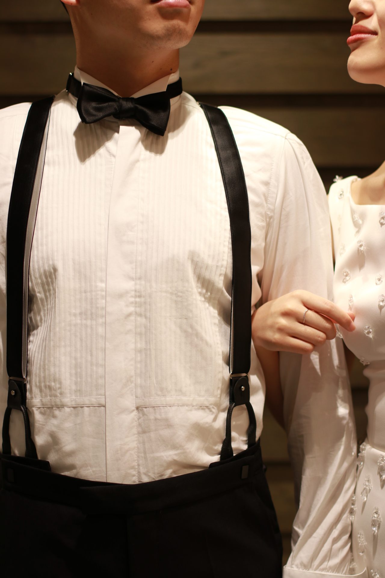 THETREATDRESSINGの提携会場パレスホテル東京などの格式あるホテルでの結婚式におススメの新郎様のスタイルは、ブラックのタキシードにプリーツシャツ、そしてブラックタイとサスペンダーを合わせた装いです 