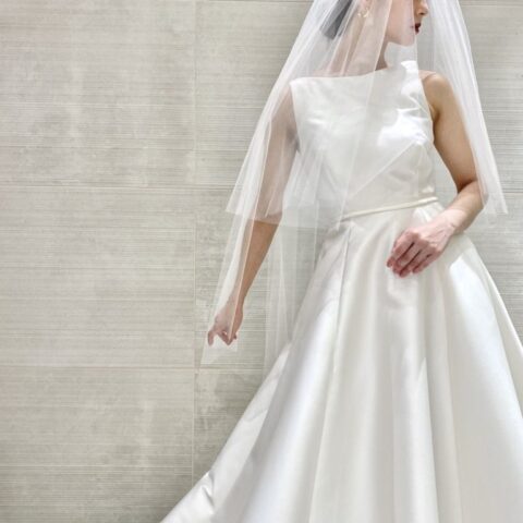 ミカドシルクの艶やかな光沢が美しいAラインのウェディングドレスには、シンプルな無地のベールをコーディネート。