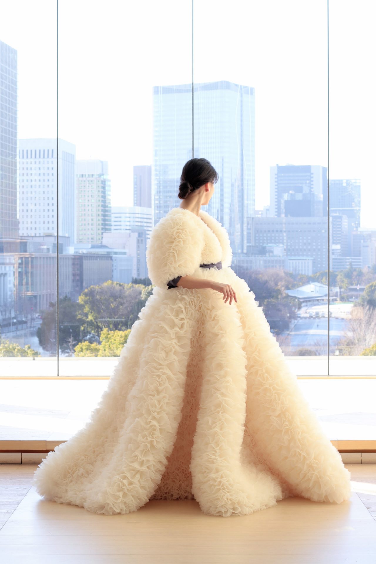 東京の人気会場、パレスホテル東京の大都会をバックにしたチャペルには、アイボリーのフリルオーガンジーが透明感を放つ、モダンなプリンセスラインのウェディングドレスがおすすめです