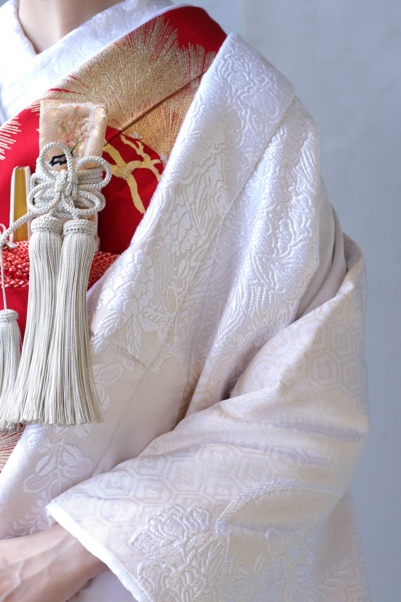 アットホームな結婚式では、白無垢に赤の掛下と金とピンクの小物を合わせると優しい印象になります。