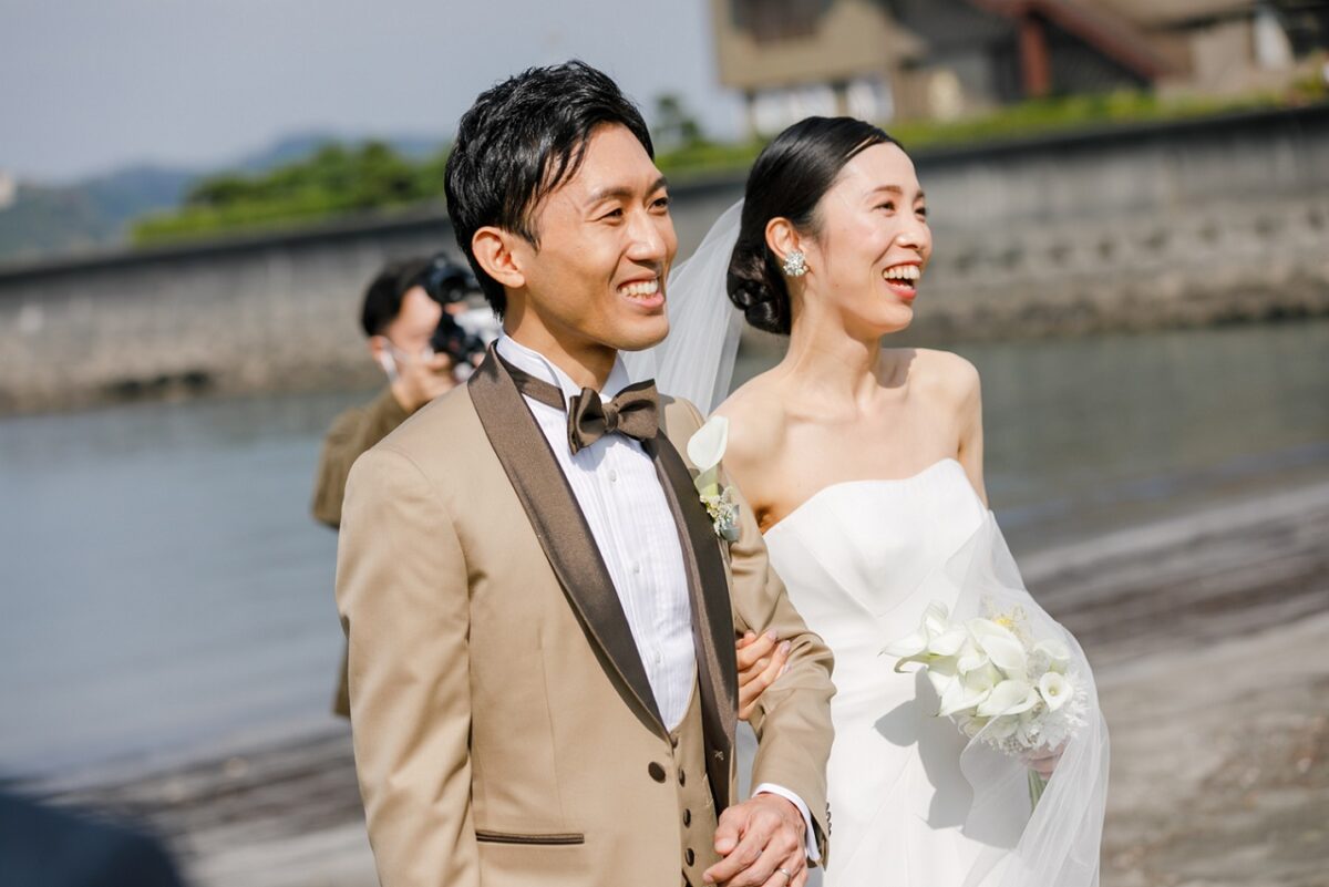結婚式参列のゲストを前に新郎新婦の幸せな笑顔が溢れます