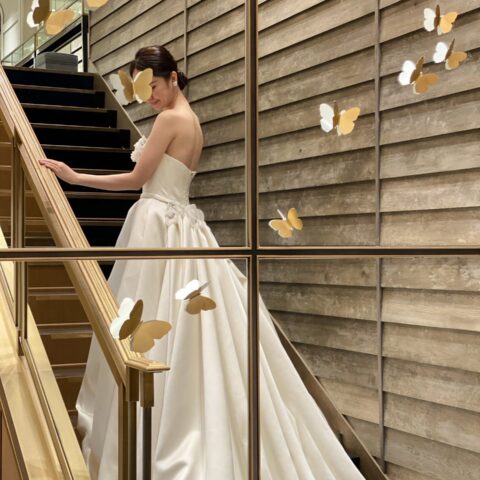 大きな階段に映えるトレーンが美しいウェディングドレス