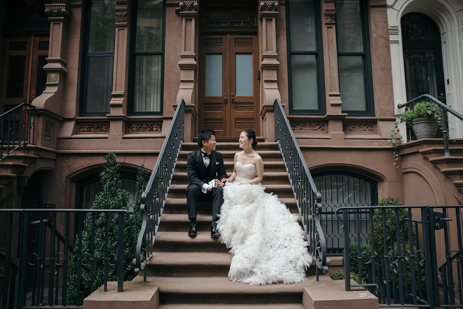 ニューヨークでの前撮り・フォトウェディングでTHE TREAT DRESSING（ザ トリート ドレッシング）の海外専用レンタルウェディングドレスとタキシードを着て階段で向かい合っているお２人。