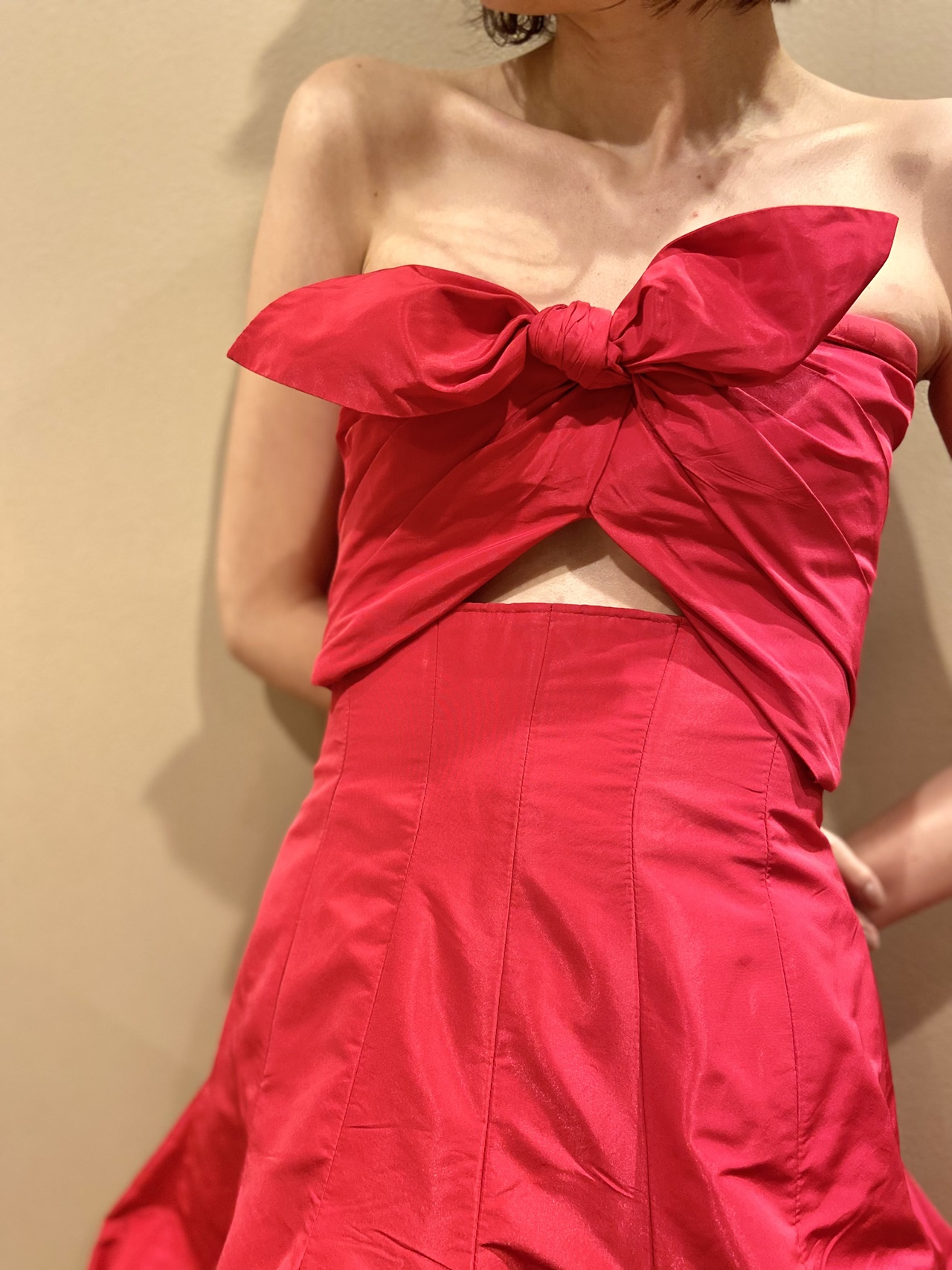 おしゃれなリボンモチーフと肌見せがヘルシーな春夏のパーティーにおすすめの赤のカラードレス