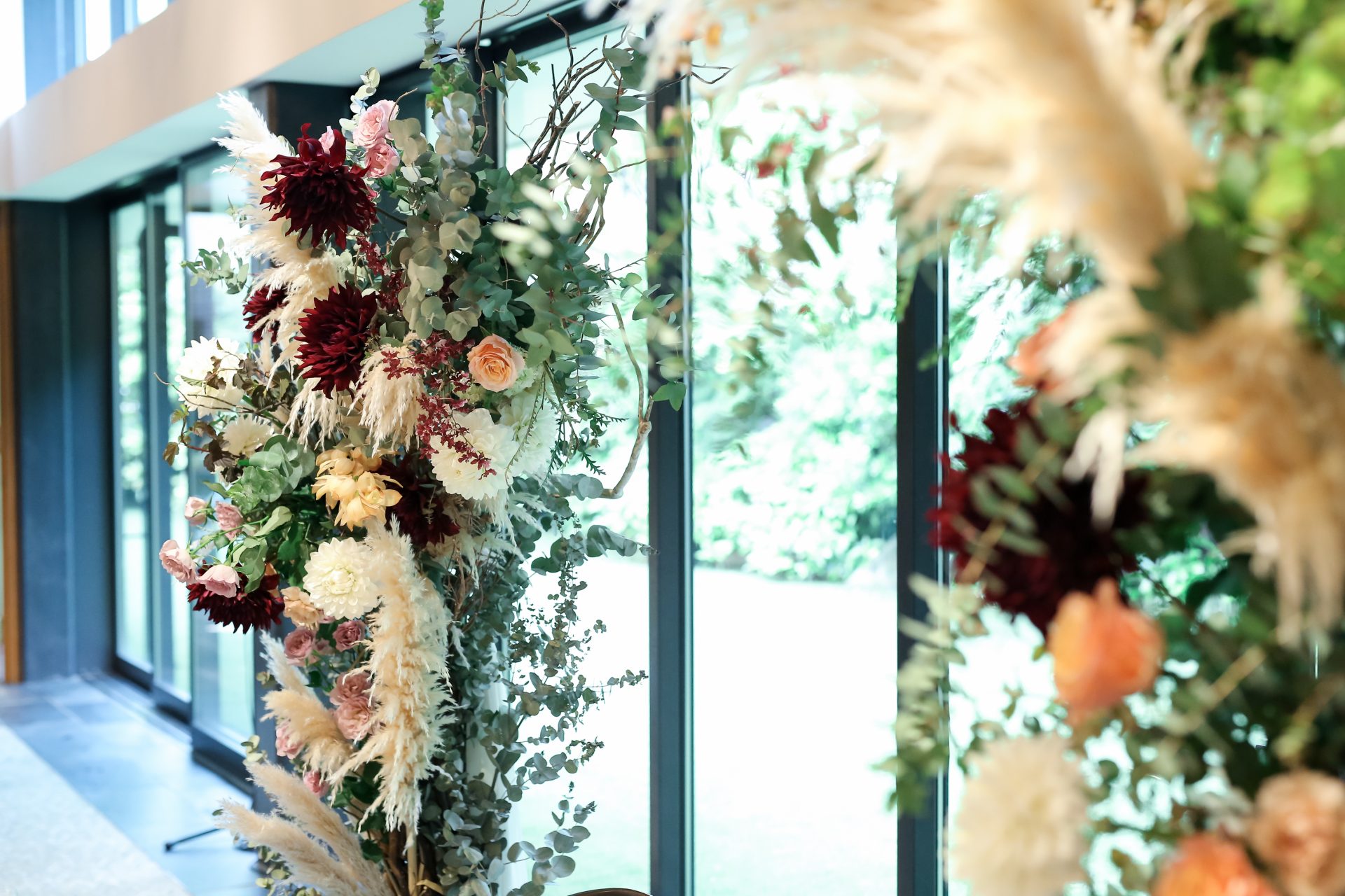 披露宴会場の装花はフラワーアーチにパンパスグラスを用いてナチュラルテイストに仕上げて