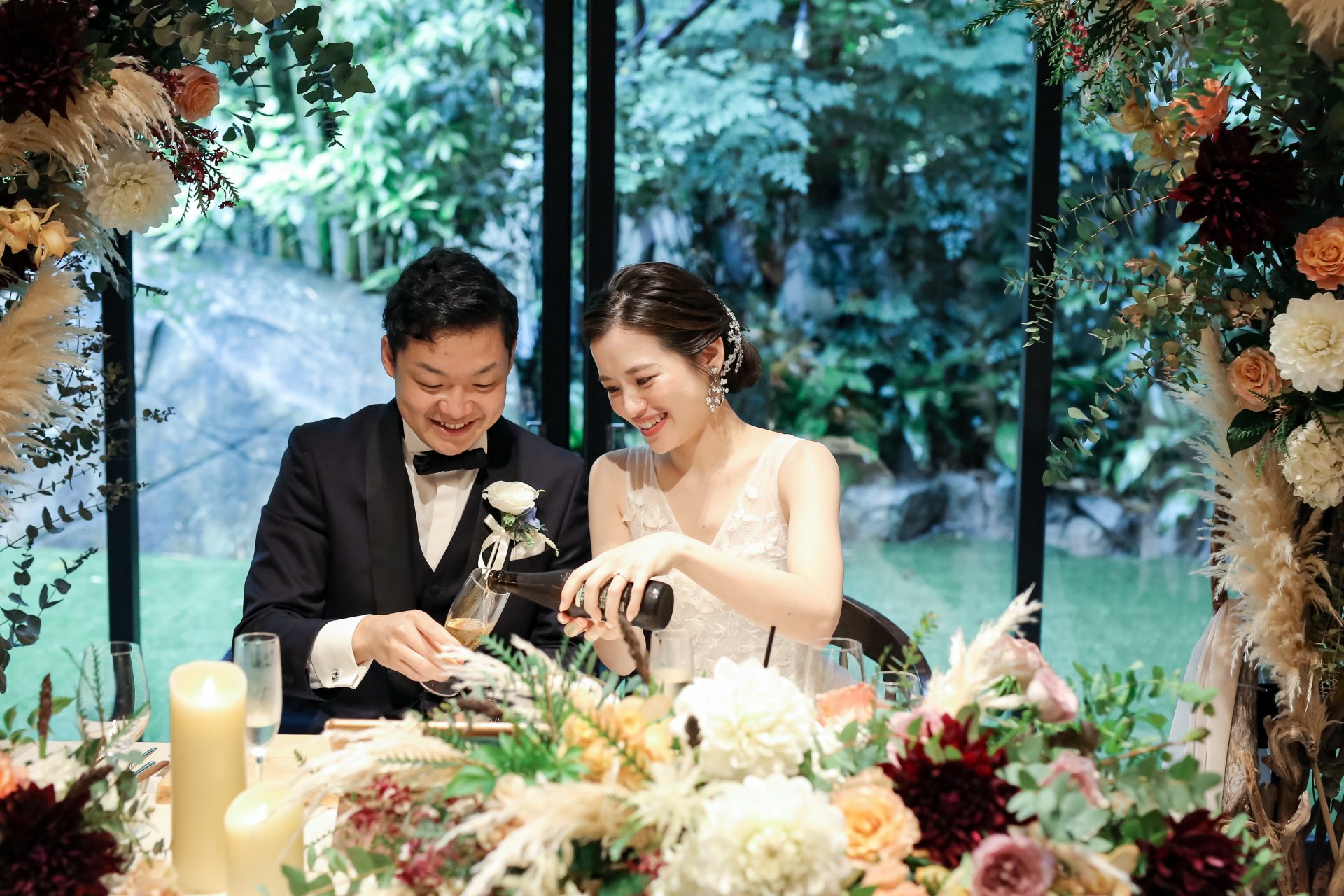 結婚式のテーブルコーディネートの装花には緑と白と暖色カラーを合わせて華やかな印象に
