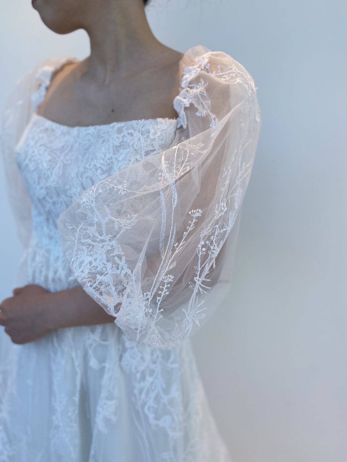 シアースリーブで透け感のあるレンタルウェディングドレスは素肌を綺麗に魅せてくれる一着