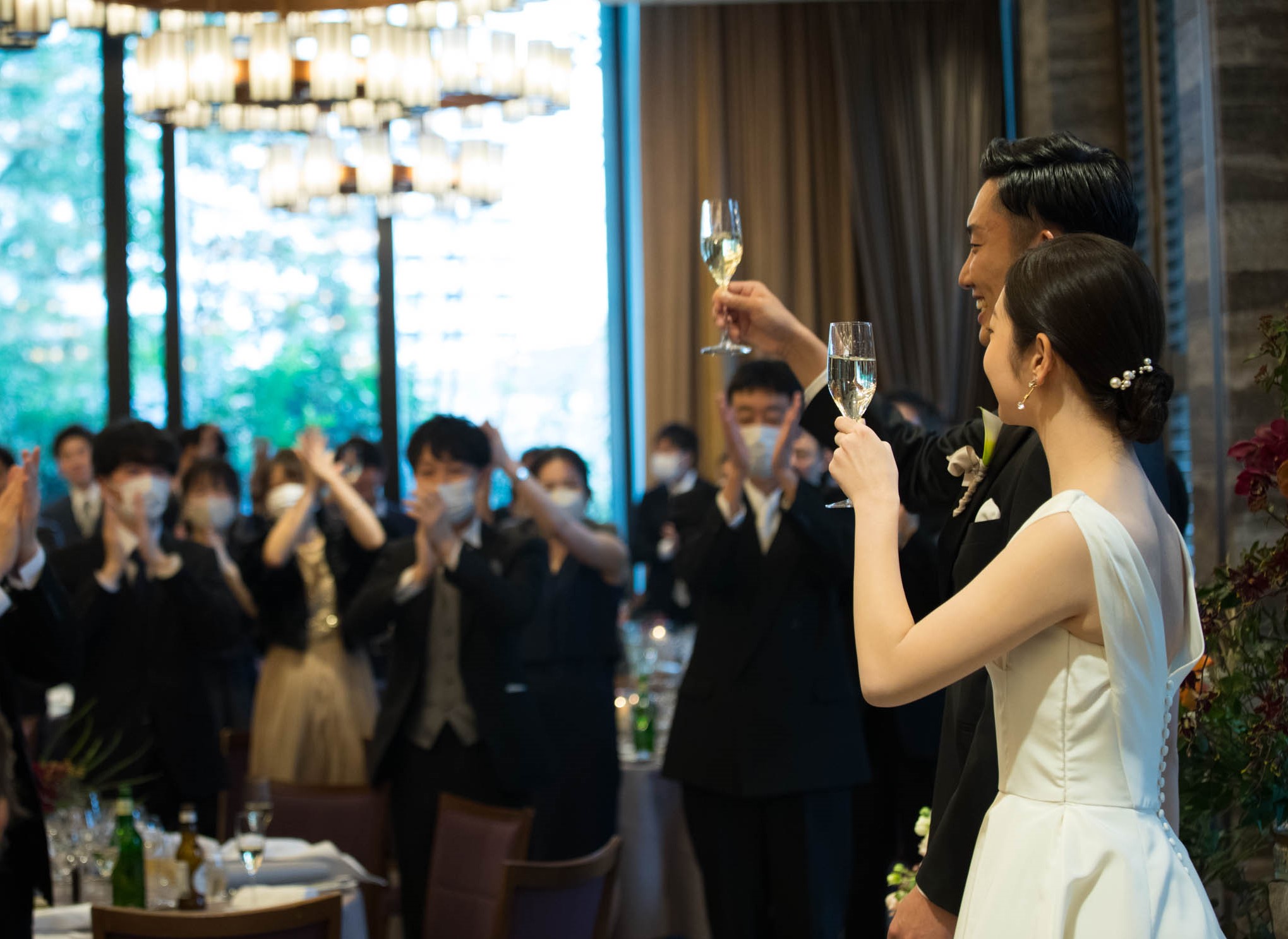 東京で人気のゲストハウス、赤坂プリンスクラシックハウスのご披露宴にて、沢山のゲストと乾杯でお祝いをする新郎新婦のお二人