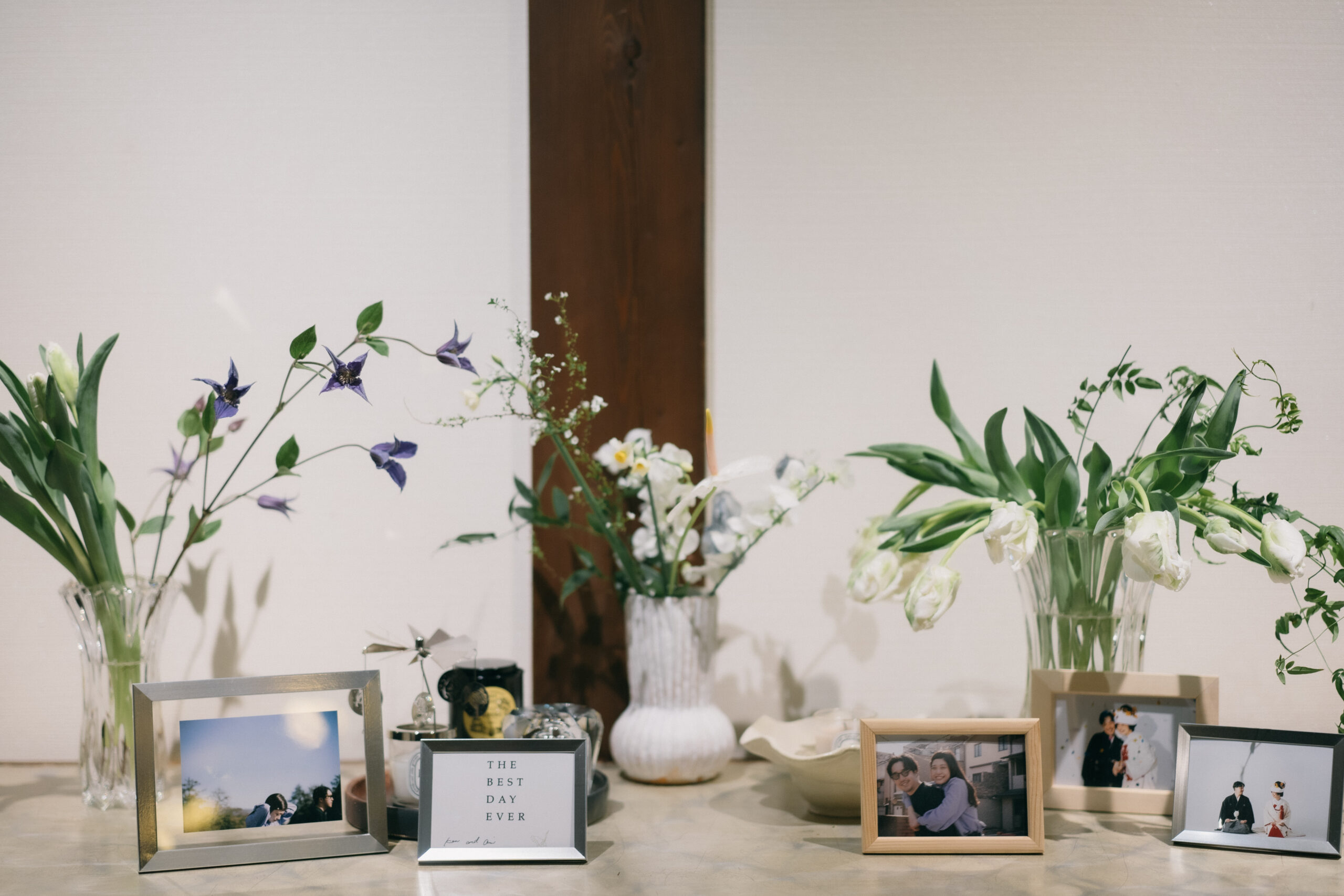新郎新婦様の思い出の写真と前撮りのお写真を飾り、透明感のある花瓶に美しいお花が印象的なウェルカムスペース