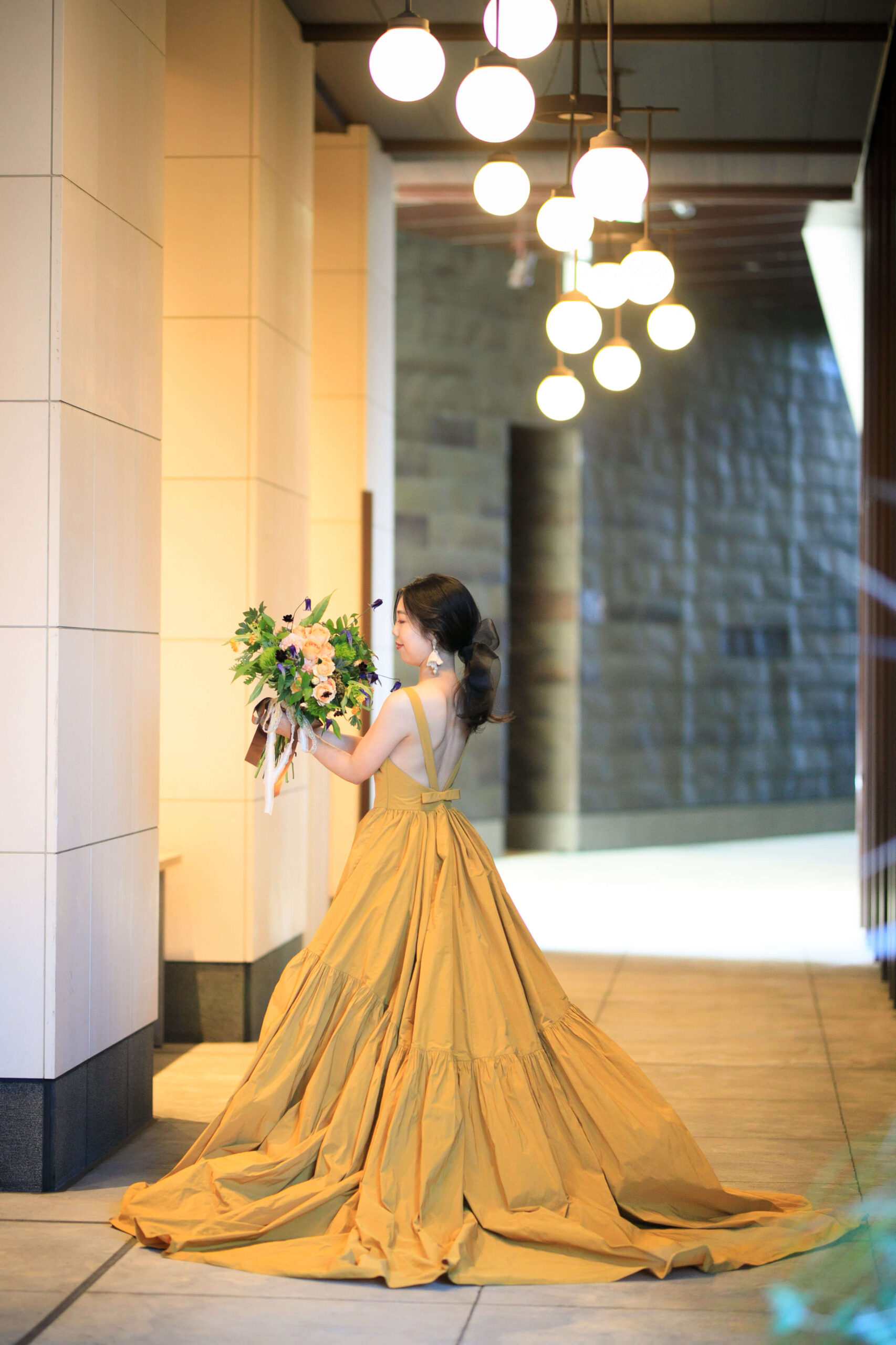 ザトリートドレッシングアディション店で人気のトリートメゾンのイエローのAラインのカラードレスにオスカーデラレンタのラフィアのイヤリングを合わせた花嫁のコーディネート