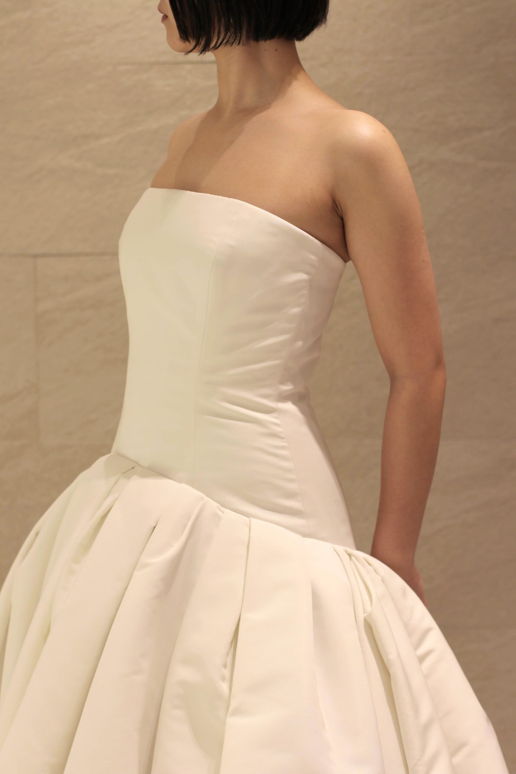 トレンドに敏感なおしゃれ花嫁にお召いただきたいのは、ストレートカットのビスチェにローウェストのスカートデザインがシンプルかつモードなオスカーデラレンタのウェディングドレスです