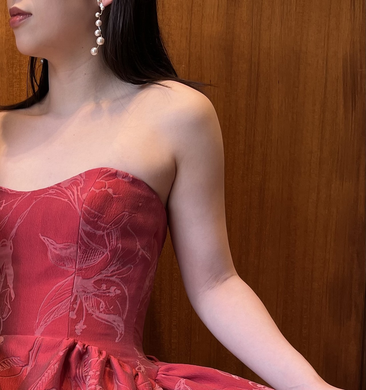濃い赤のカラードレスには、ゆれるパールのイヤリングを合わせたおしゃれで上品なコーディネートを