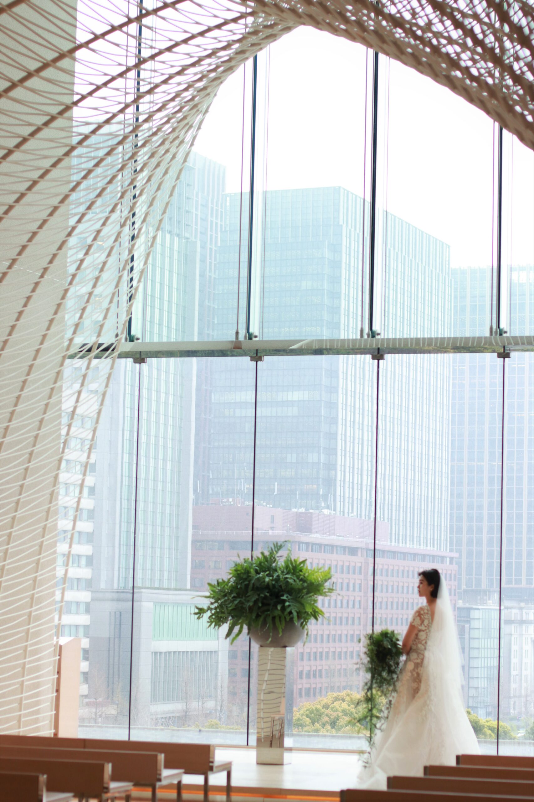 東京・丸の内の一等地に構えるパレスホテル東京のウェディングチャペルは大きな窓から差し込む柔らかな自然光が魅力です。祭壇に立つお二人を包み込むように計算されたアーチのデザインは結婚式の一体感を演出します。