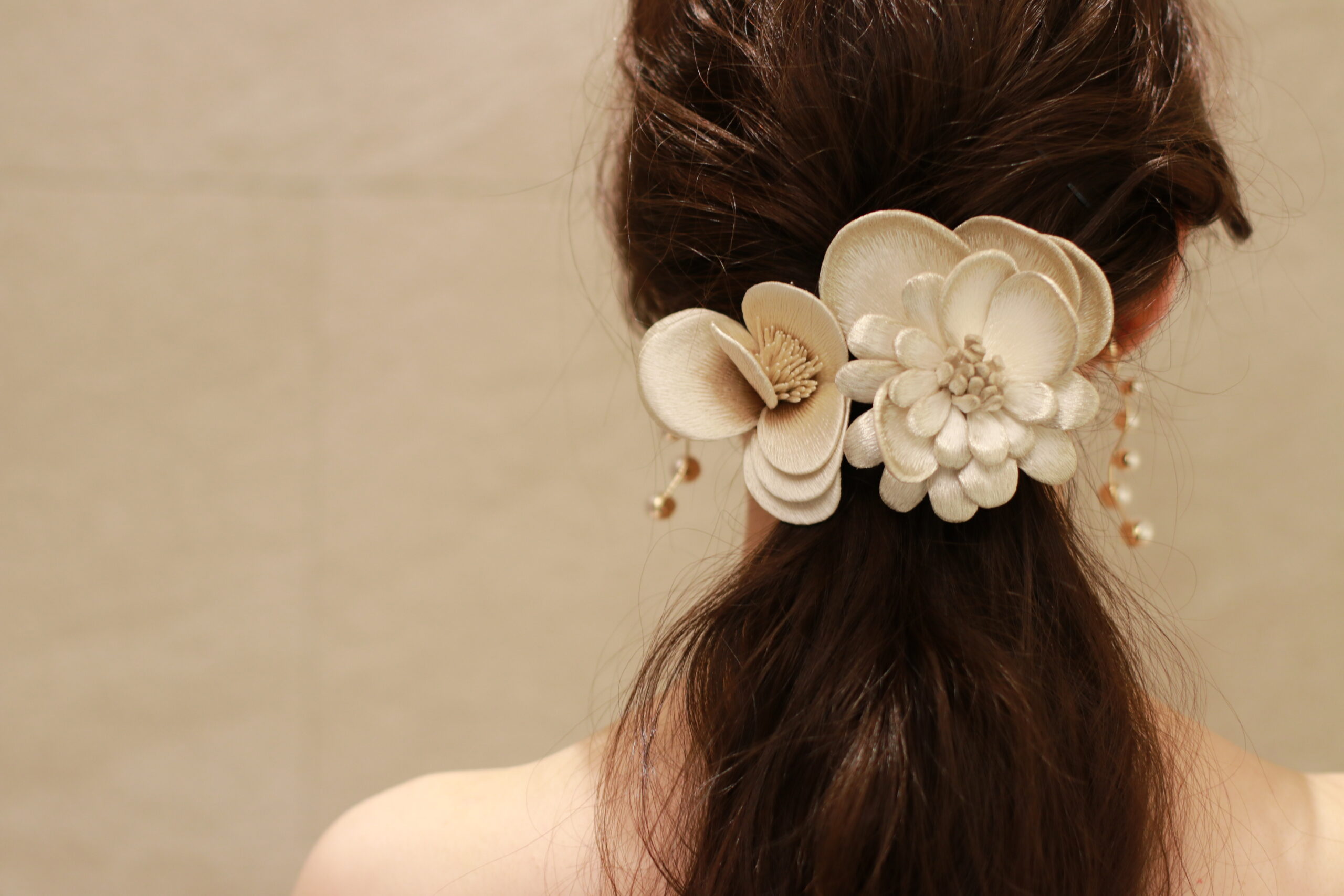 THE TREAT DRESSINGが取り扱う髪飾りは、群馬県桐生市の伝統産業である横振り刺繡によってつくられた架空のお花で、緩くまとめたローポニーのヘアスタイルにとてもよく合います