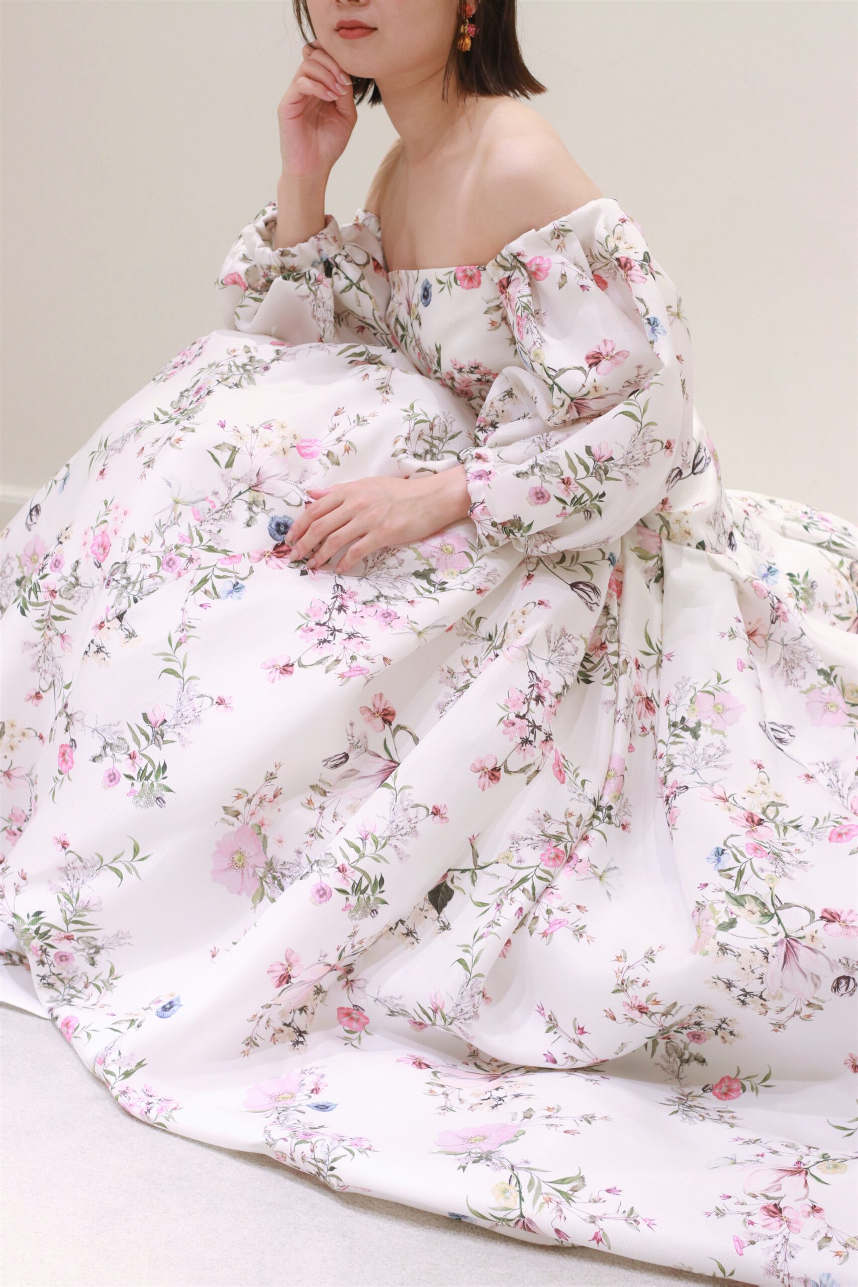 モニークルイリエの新作、淡いピンクのフラワーデザインが魅力のカラードレスは、サムシングカラーである華やかなイヤリングと合わせてコーディネートをすることで、モダンでハッピーな雰囲気を演出いたします