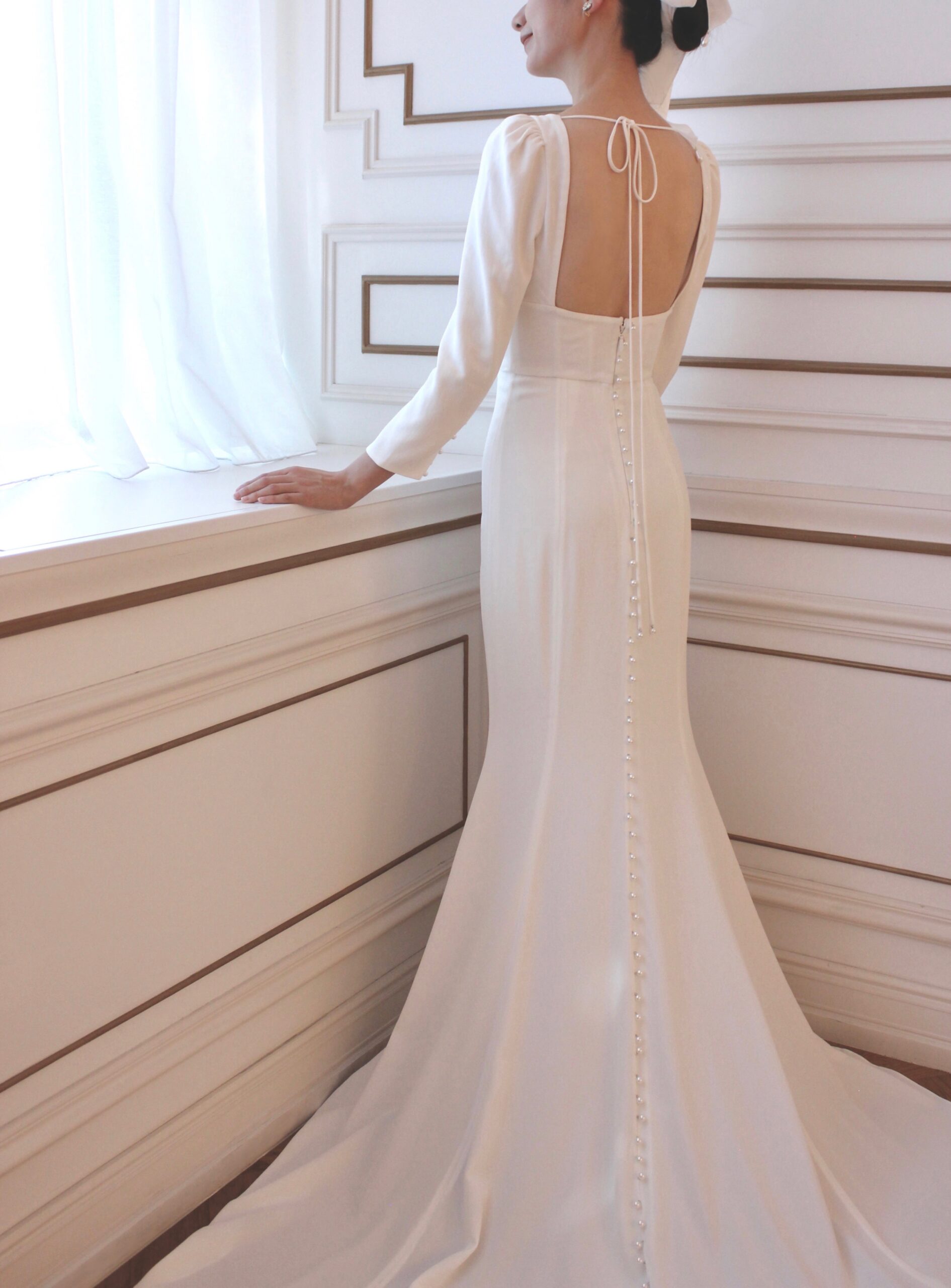 モニーク ルイリエの長く広がるトレーンが印象的な上品でエレガントな細身でシンプルなウェディングドレス