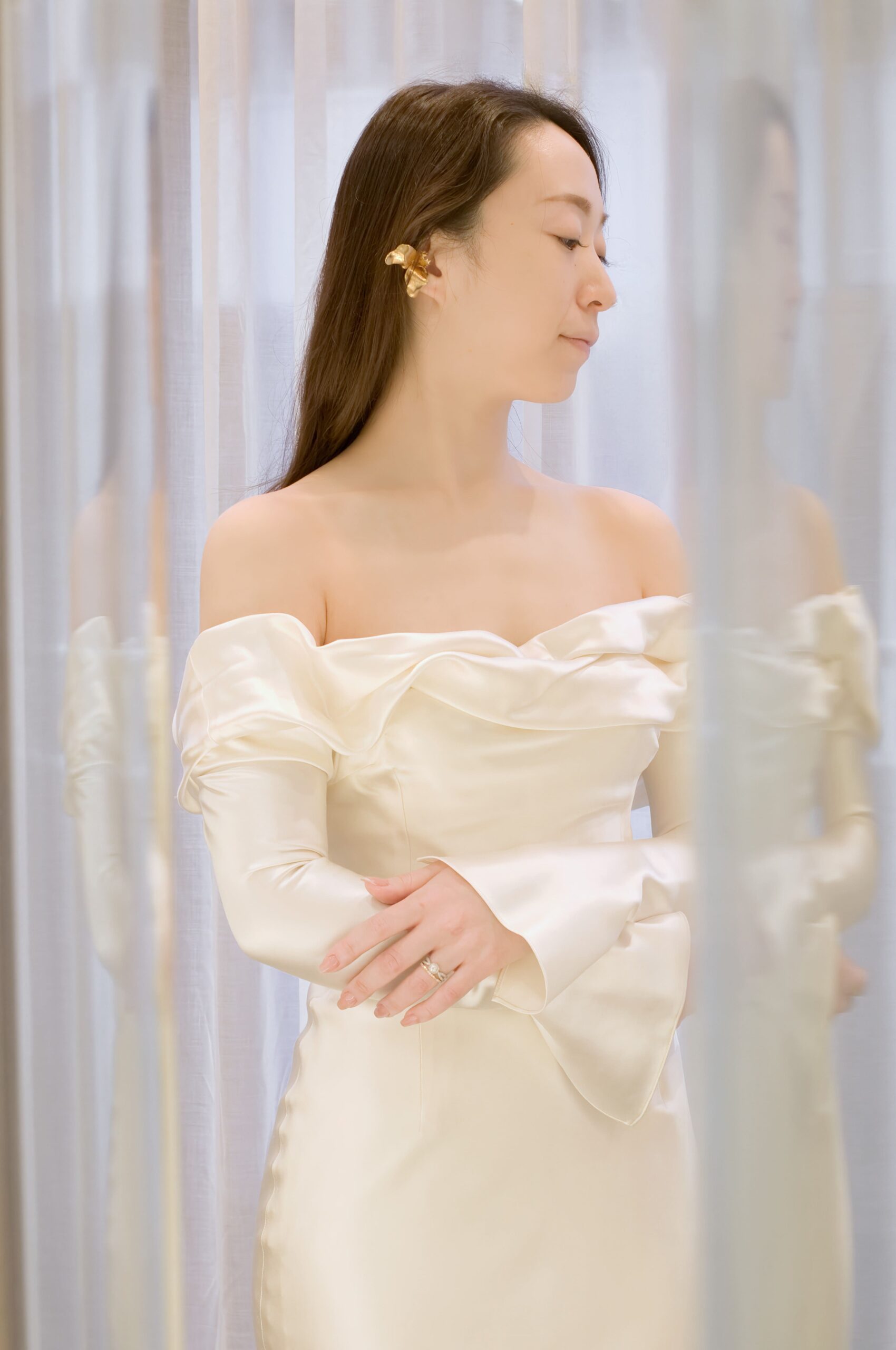 東京・表参道の人気ドレスショップ、ザトリートドレッシング　アディション店に入荷した新作ウェディングドレスは、シルク素材のオフショルダーがデコルテを美しく魅せるスレンダーラインのウェディングドレスです