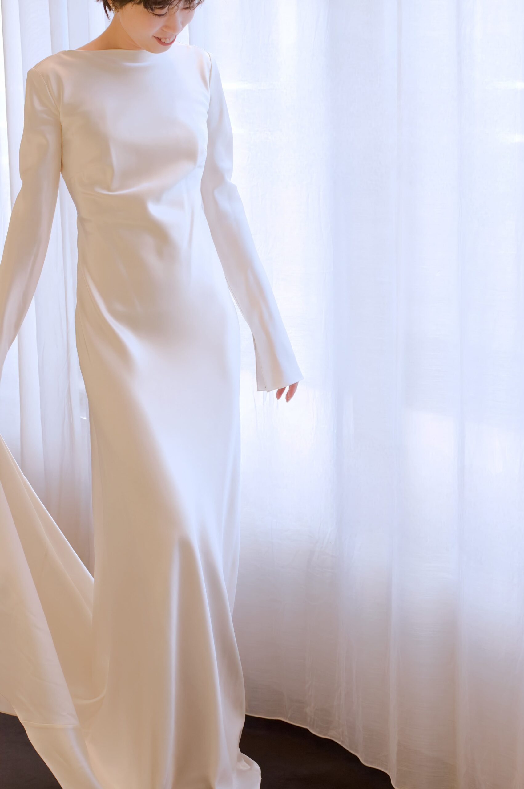 自然光差し込むガーデンやチャペルにお勧めの新作ウェディングドレスは、シルクの艶が美しく輝くシンプルで大人っぽいロングスリーブのデザインです
