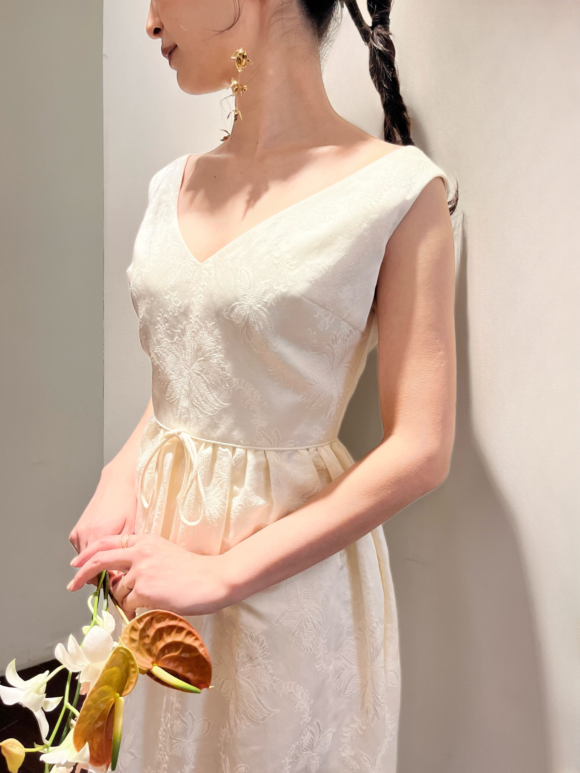 肩付きでリラックス感ありお花の刺繍が映えるマルカリアンのスレンダーラインのウェディングドレスに大人でおしゃれなゴールドのイヤリングを合わせた神戸エリアのおしゃれなプレ花嫁におすすめしたいコーディネートのご紹介