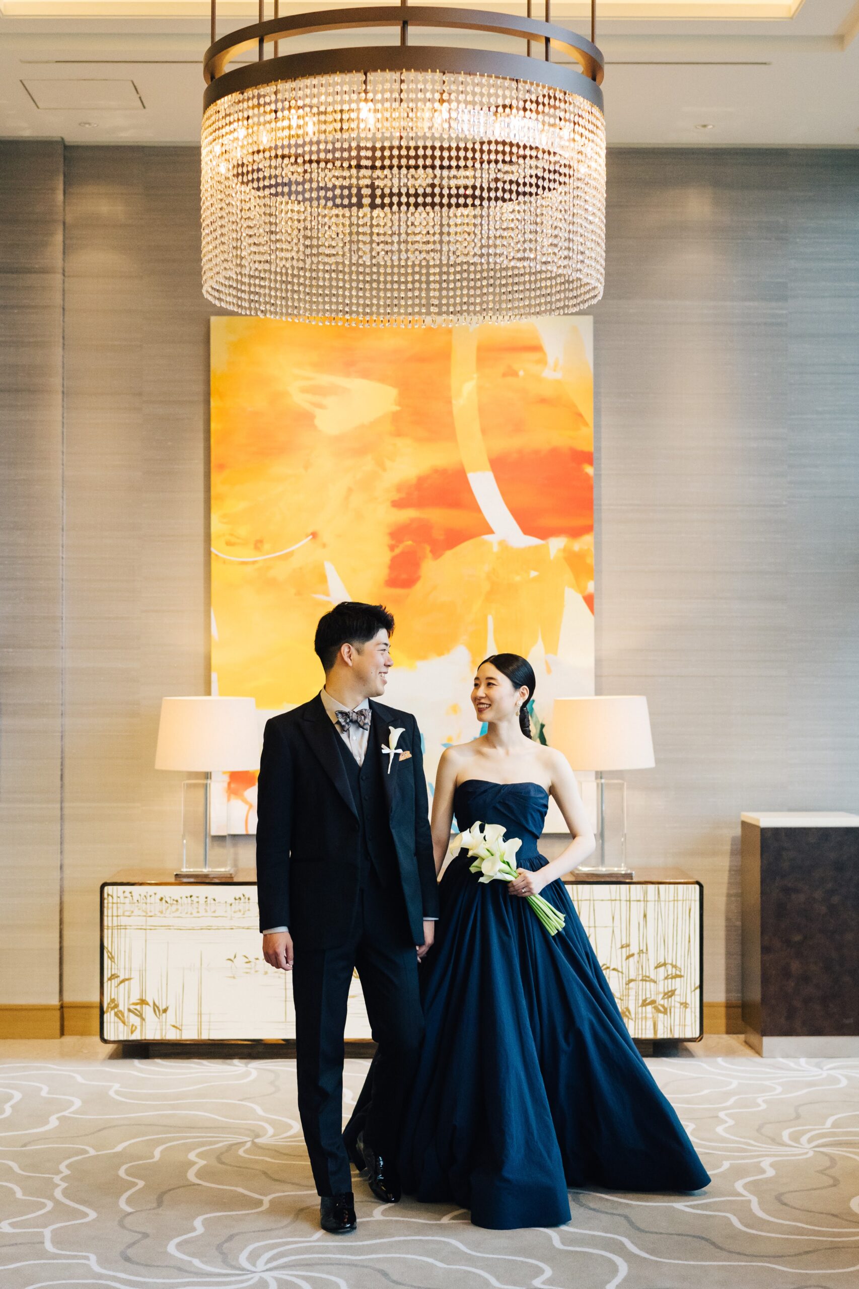 パレスホテル東京の山吹のホワイエにてお色直しのネイビーのカラードレスとタキシードを着た新郎新婦
