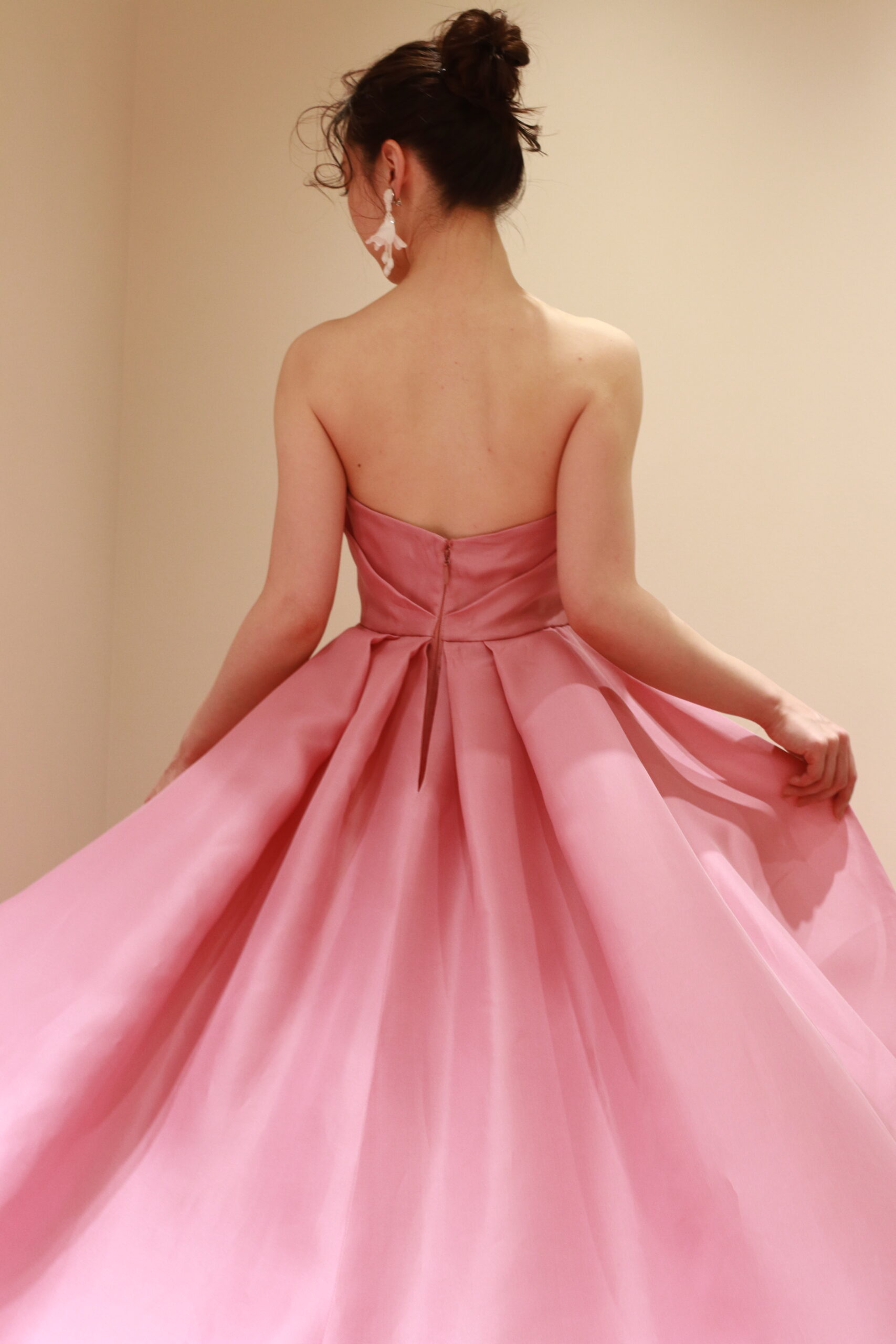 表参道のトリートドレッシングアディション店に入荷したモニークルイリエのピンクのカラードレス、花嫁の動きに合わせて華やかなトレーンが揺らめきます、
