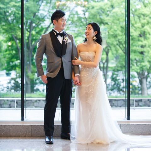 パレスホテル東京での結婚式のご紹介。 ザトリートドレッシングアディション店でお取り扱いしている広瀬すずがドラマで着用したオスカー デ ラ レンタのウェディングドレスをお色直しでご新婦様とグレーのタキシードでエスコートをするご新郎様。