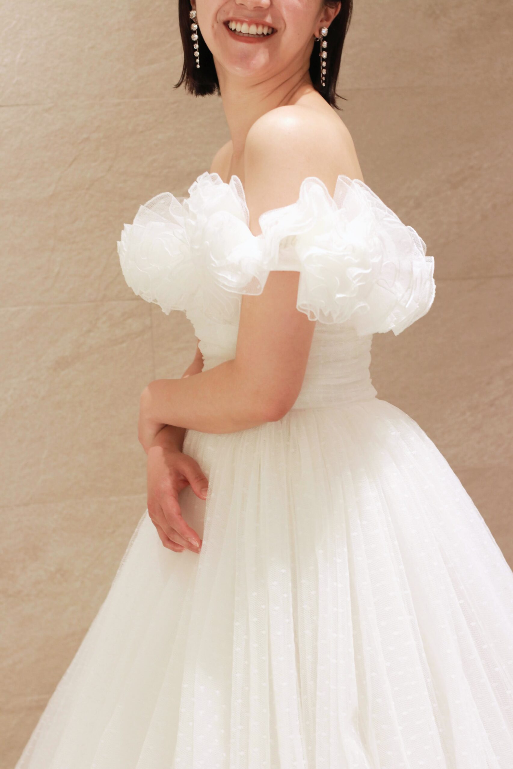 東京の結婚式場にてご結婚式を予定される花嫁におすすめしたい、お洒落なウェディングドレスは、デコルテを華やかに魅せるフリルが印象的なプリンセスラインのインポートのウェディングドレスです