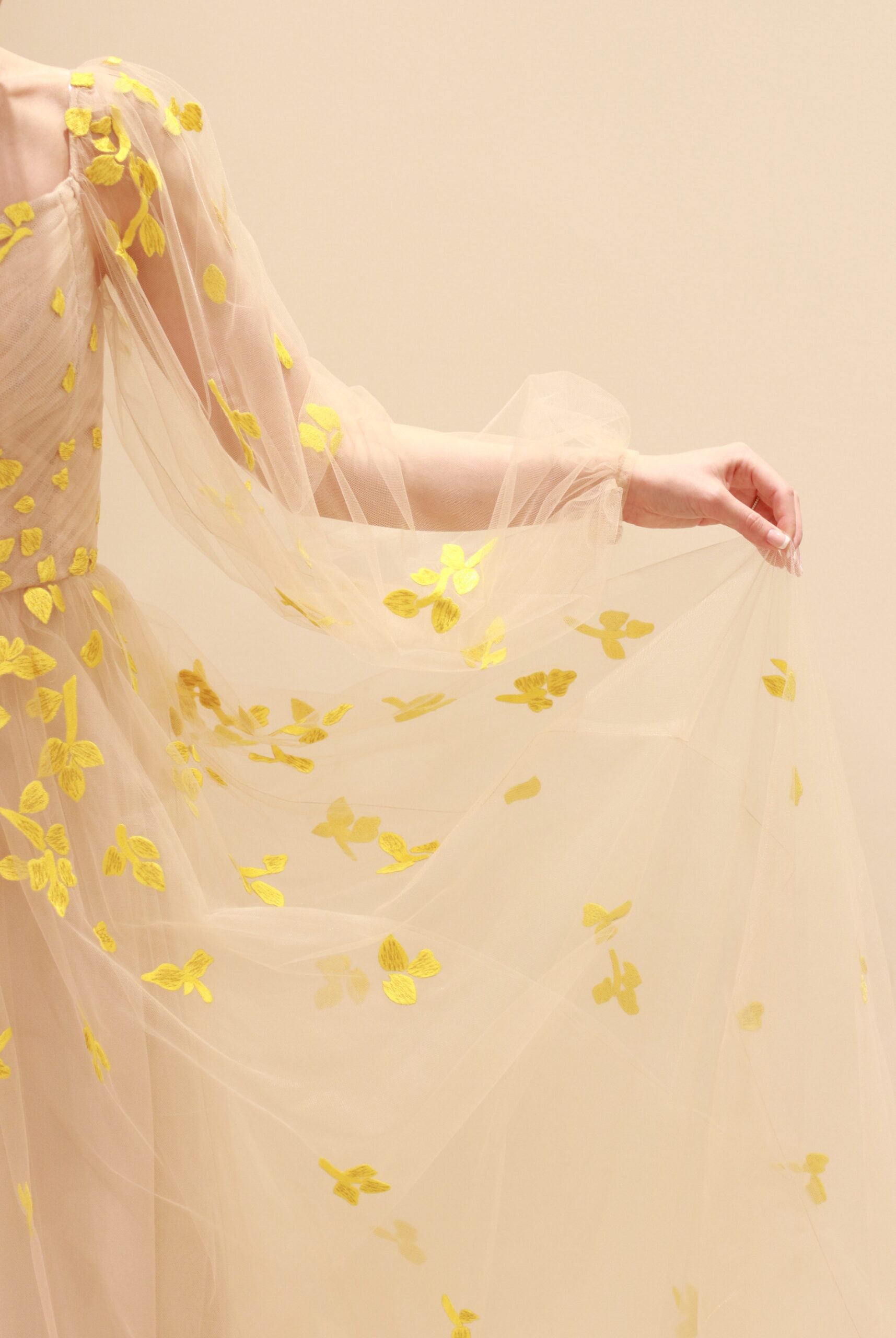 ベージュの柔らかなチュールの上に施されたイエローのフラワー刺繍は花嫁の動きに合わせて柔らかく舞い、会場の雰囲気を華やかに彩ります。