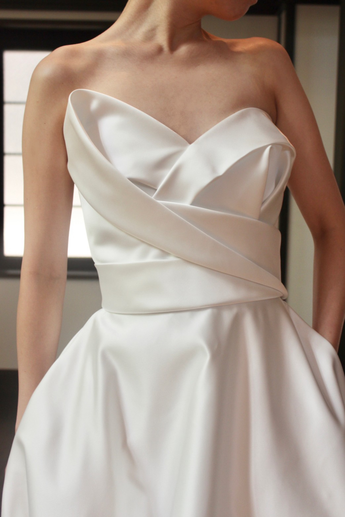 胸元の立体的なデザインが特徴的なデコルテを美しく見せてくれるサテンAラインのウェディングドレス