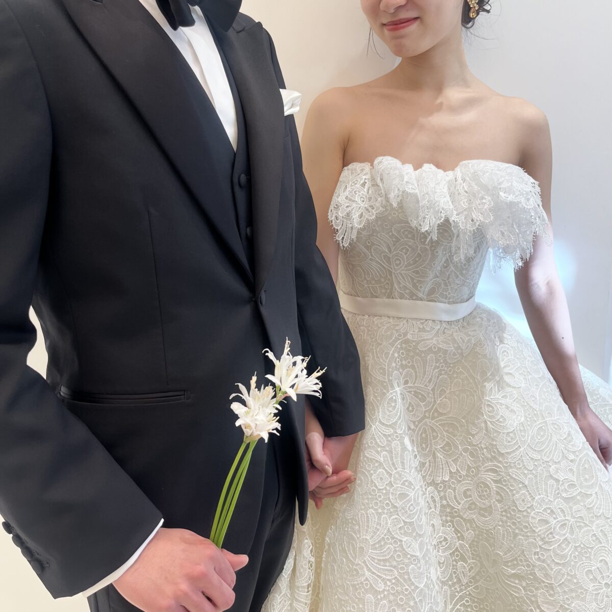 神戸エリアで結婚式や前撮りをされる新郎新婦にお勧めのトリート神戸店にて取り扱いのあるブラックタキシードとエリーサーブブライダルの総レースのウェディングドレス