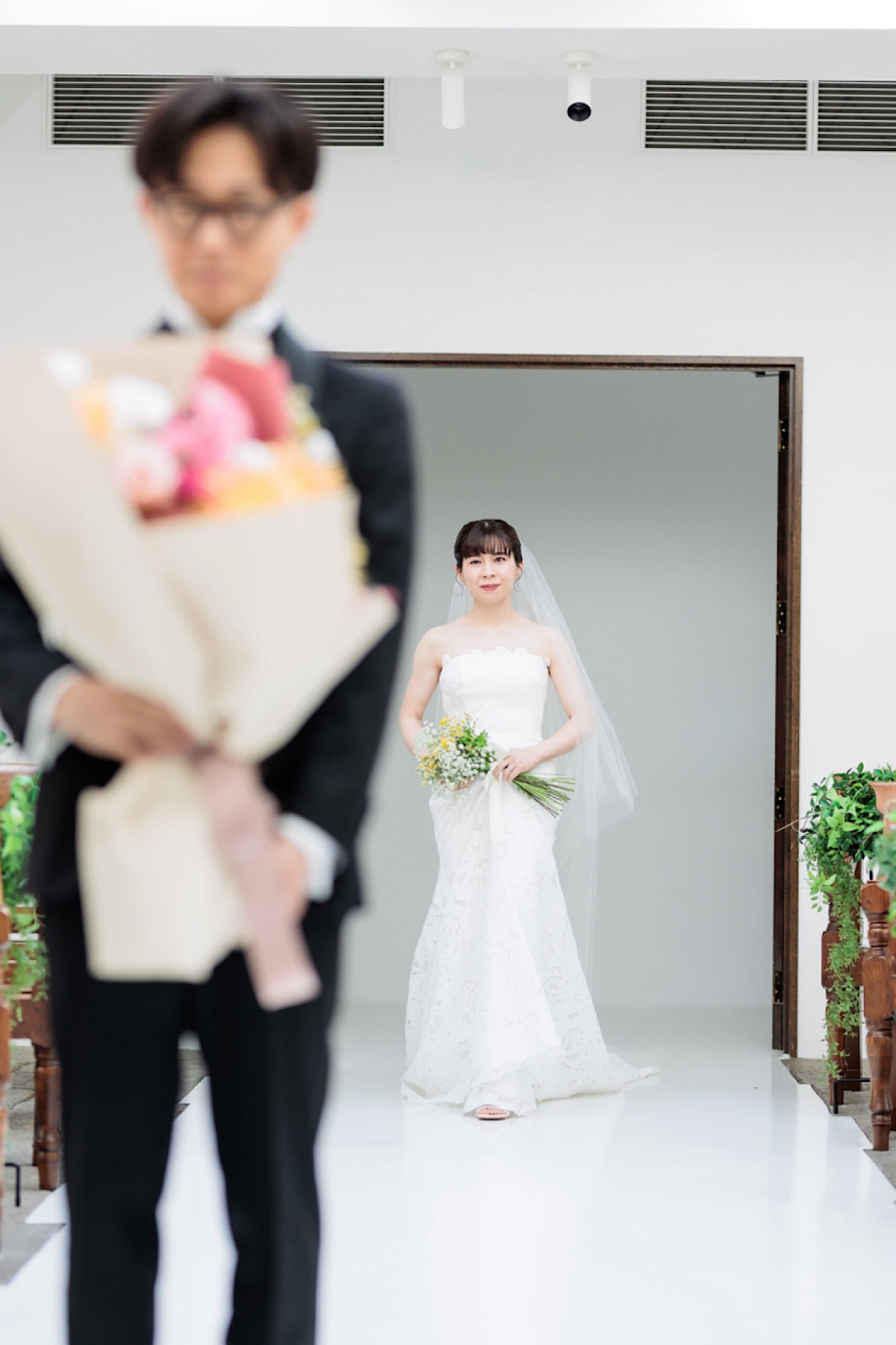 緑溢れるナチュラルな名古屋エリアのザ ナンザンハウスの白いチャペルで行う、レラローズのウェディングドレスを身に纏った花嫁のファーストミート