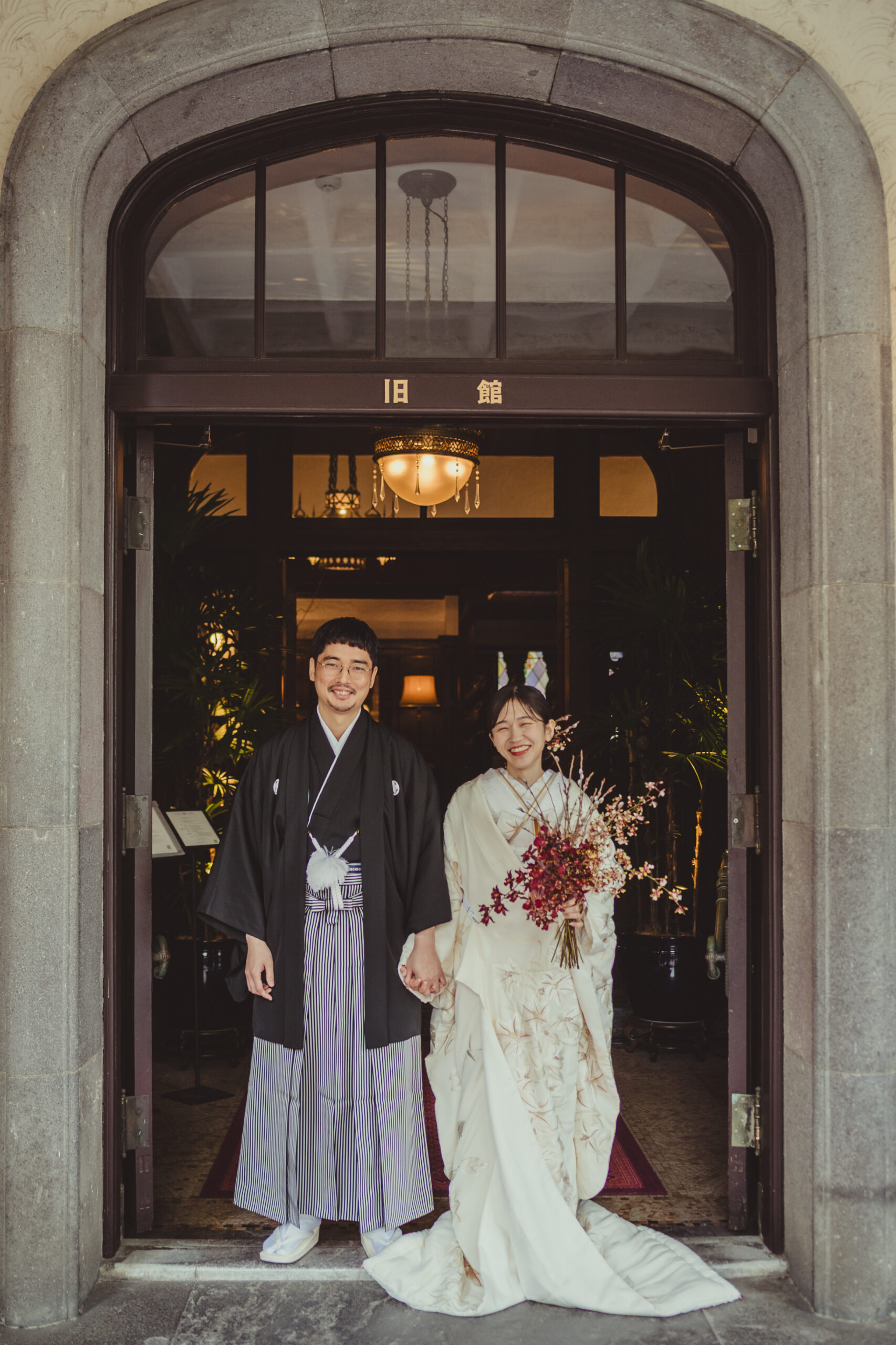 THETREATDRESSINGの提携会場、赤坂プリンスクラシックハウスの外観をバックに白無垢と袴を身に纏い微笑まれているご新郎ご新婦様。