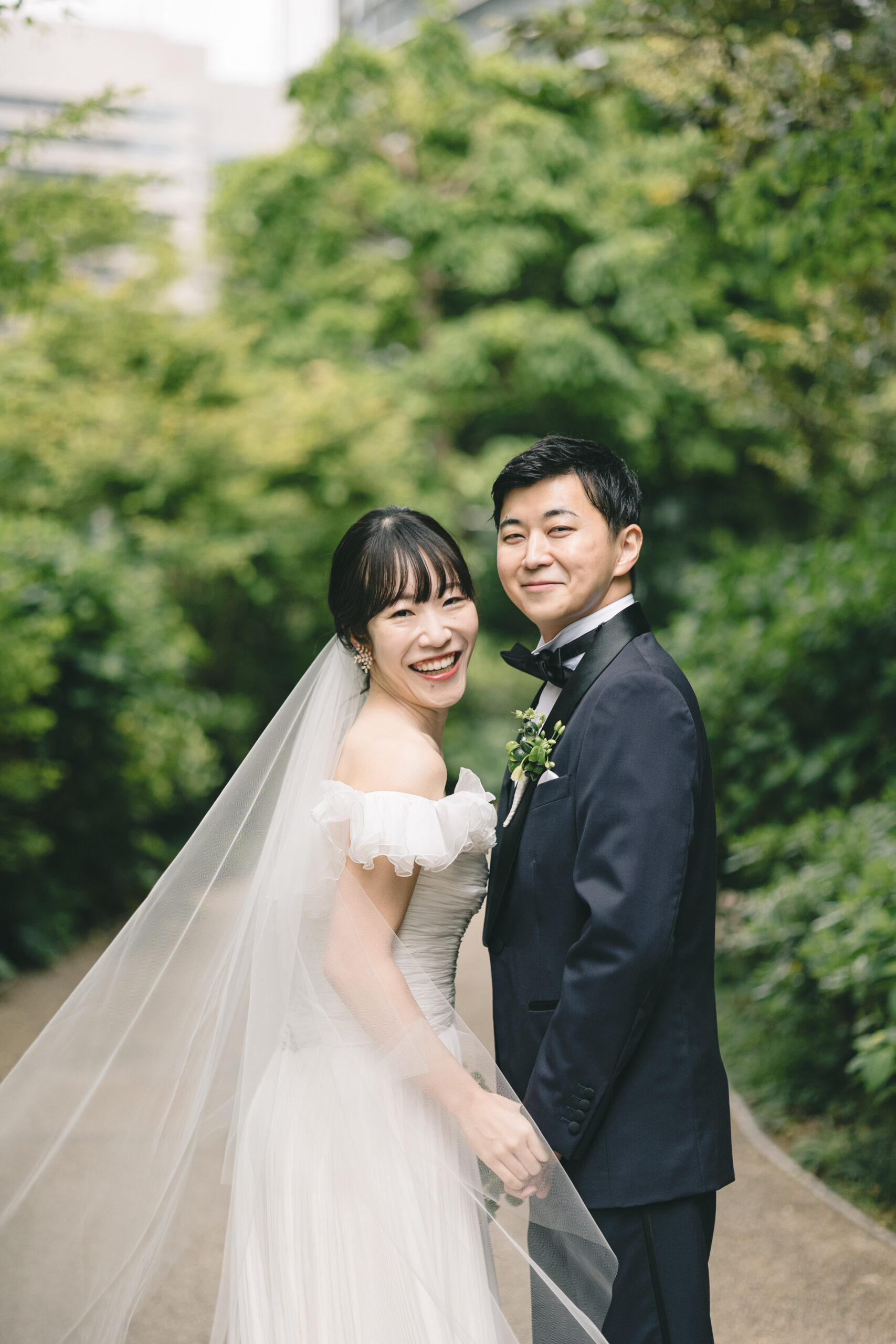 沢山の緑の中、トリートが扱うオートクチュールブランドのジャンバティスタヴァリのウェディングドレスを纏って笑顔で過ごすお二人。