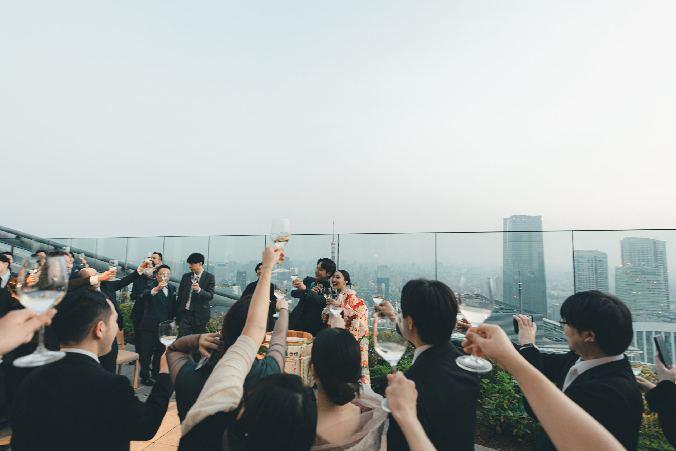 アンダーズ東京のルーフトップテラスにてタキシードに身を包むモダンさを感じるご新郎様と、日本の伝統衣裳である赤の色打掛を纏いゲストの皆様をお時間を過ごされるお二人