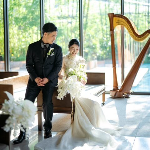 オリエンタルホテルのチャペルで温かい光に包まれながら微笑む新郎新婦