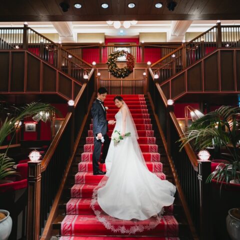 ザ コンダーハウスの赤の絨毯が特徴的な大階段ににお二人のお衣裳がとても綺麗に映えます