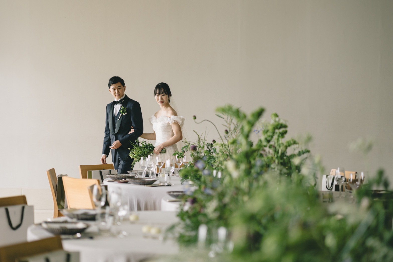 トリートドレッシングの提携会場、アンダーズ東京の洗練された空間に草花を沢山添えた披露宴会場で過ごすお二人。